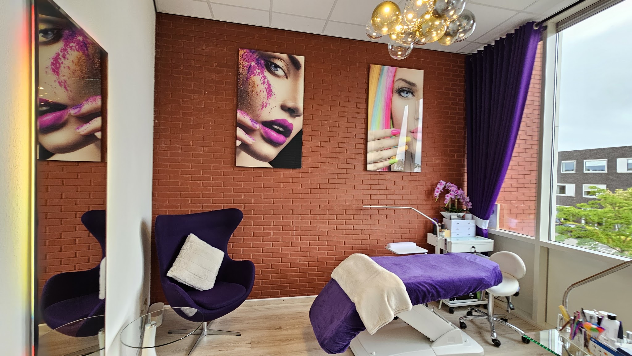 De behandelkamer van Beautify Me by B, met bakstenen muur en paarse behandelbank